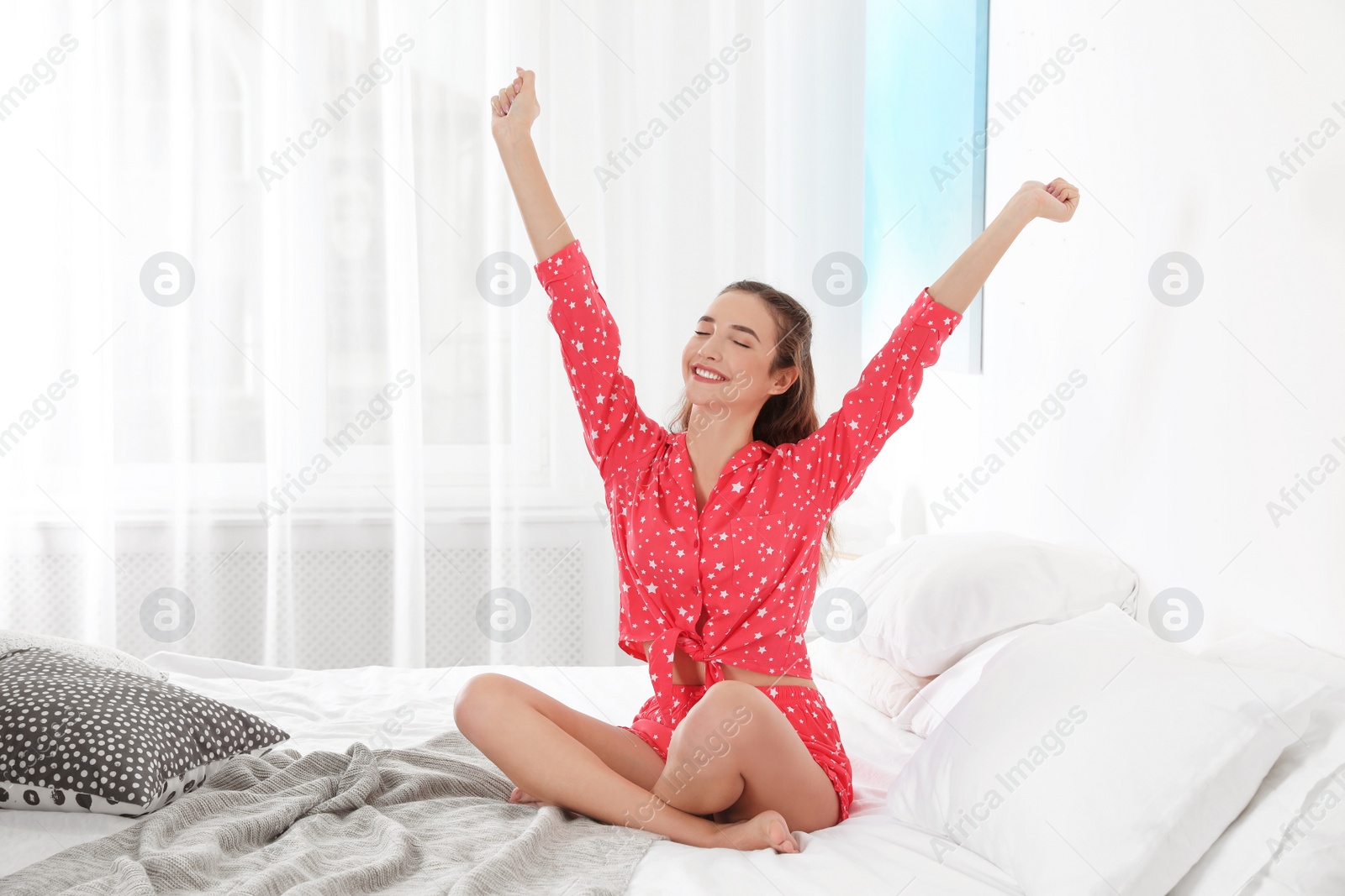 Photo of Young woman stretching on bed at home. Morning fitness