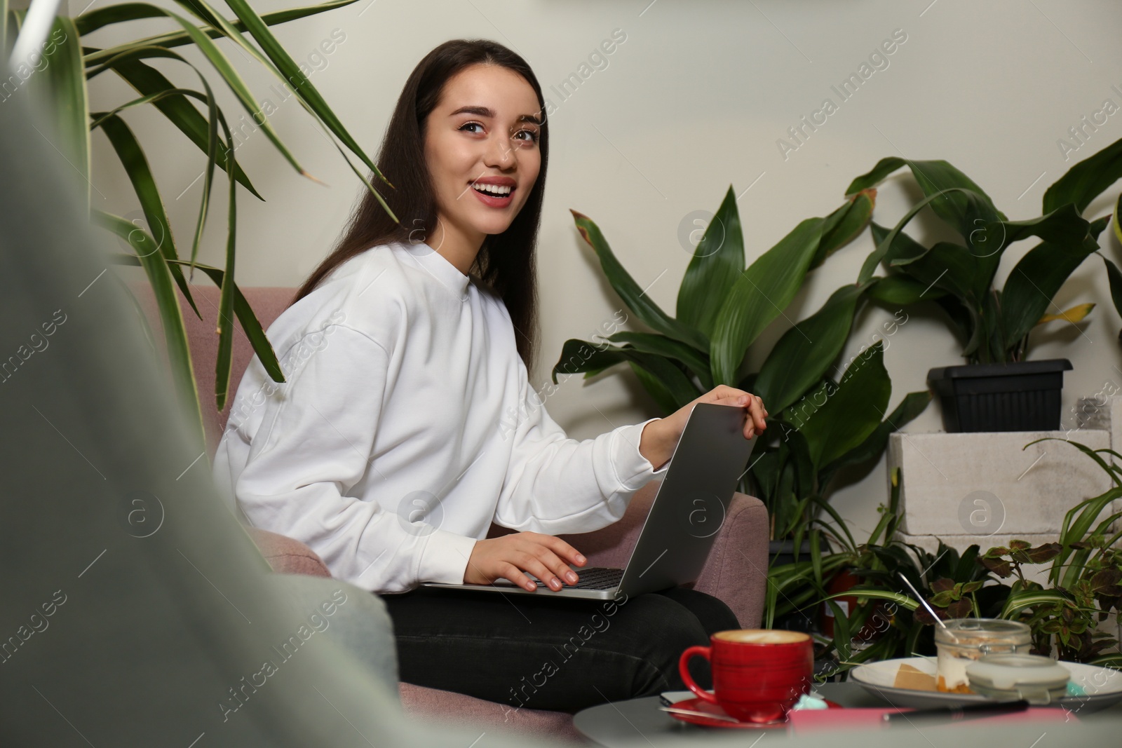 Photo of Young blogger working with laptop in office