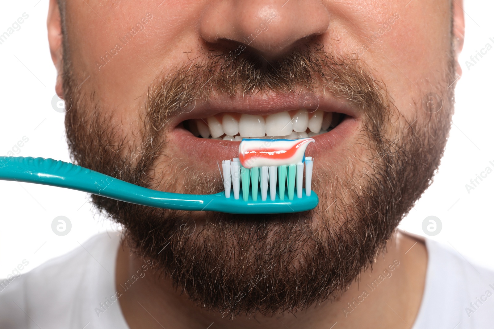 Photo of Man brushing teeth with paste on white background, closeup. Dental care