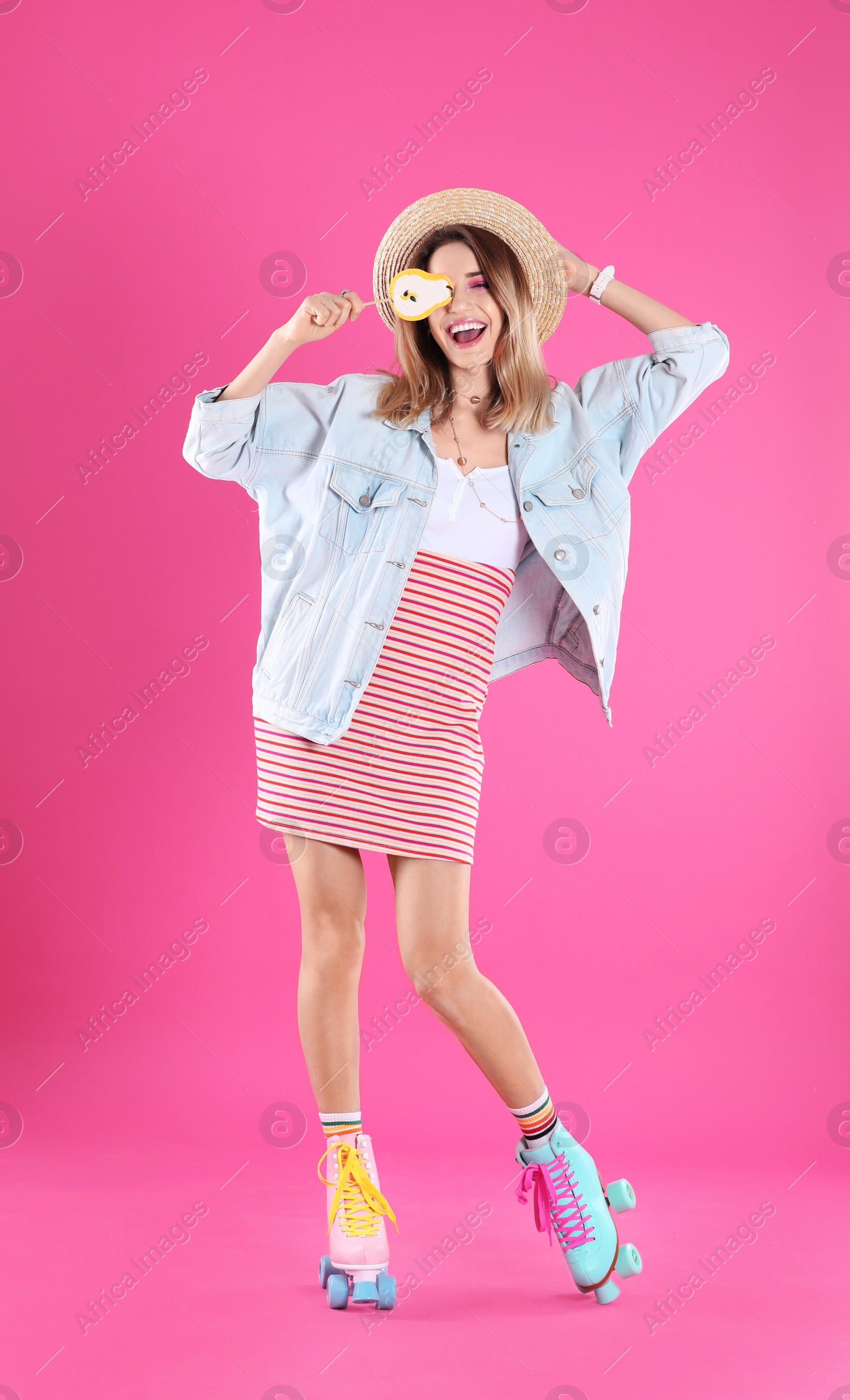 Photo of Young woman with lollipop and retro roller skates on color background