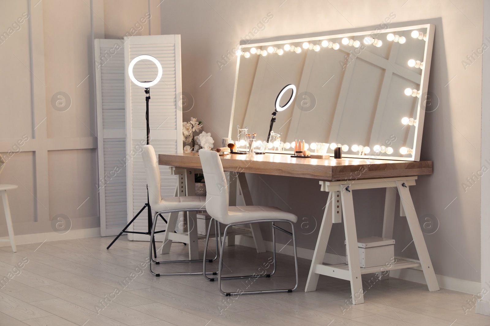 Photo of Modern mirror with light bulbs on dressing table in makeup room