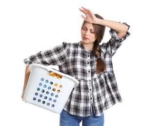 Tired young woman holding basket with laundry on white background