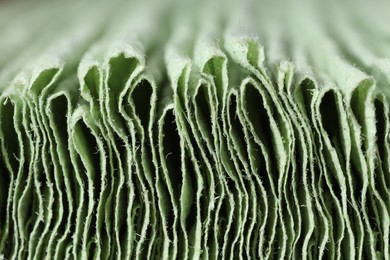Texture of stacked light green paper napkins as background, macro view