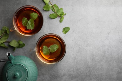 Photo of Aromatic herbal tea with mint on grey table, flat lay. Space for text