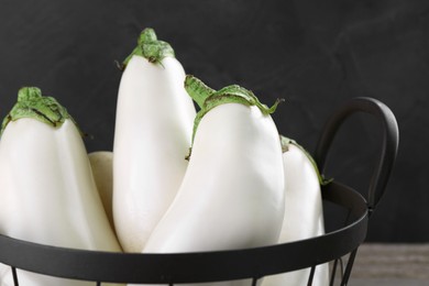 Many fresh white eggplants in metal basket, closeup