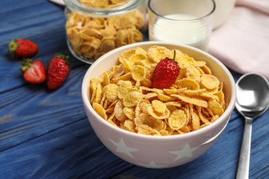Photo of Bowl with healthy cornflakes and strawberry served on wooden table
