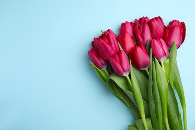Photo of Many beautiful tulips on light blue background, flat lay. Space for text