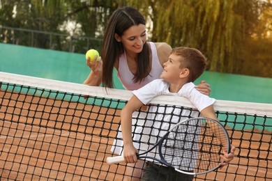 Photo of Mother with her son on tennis court
