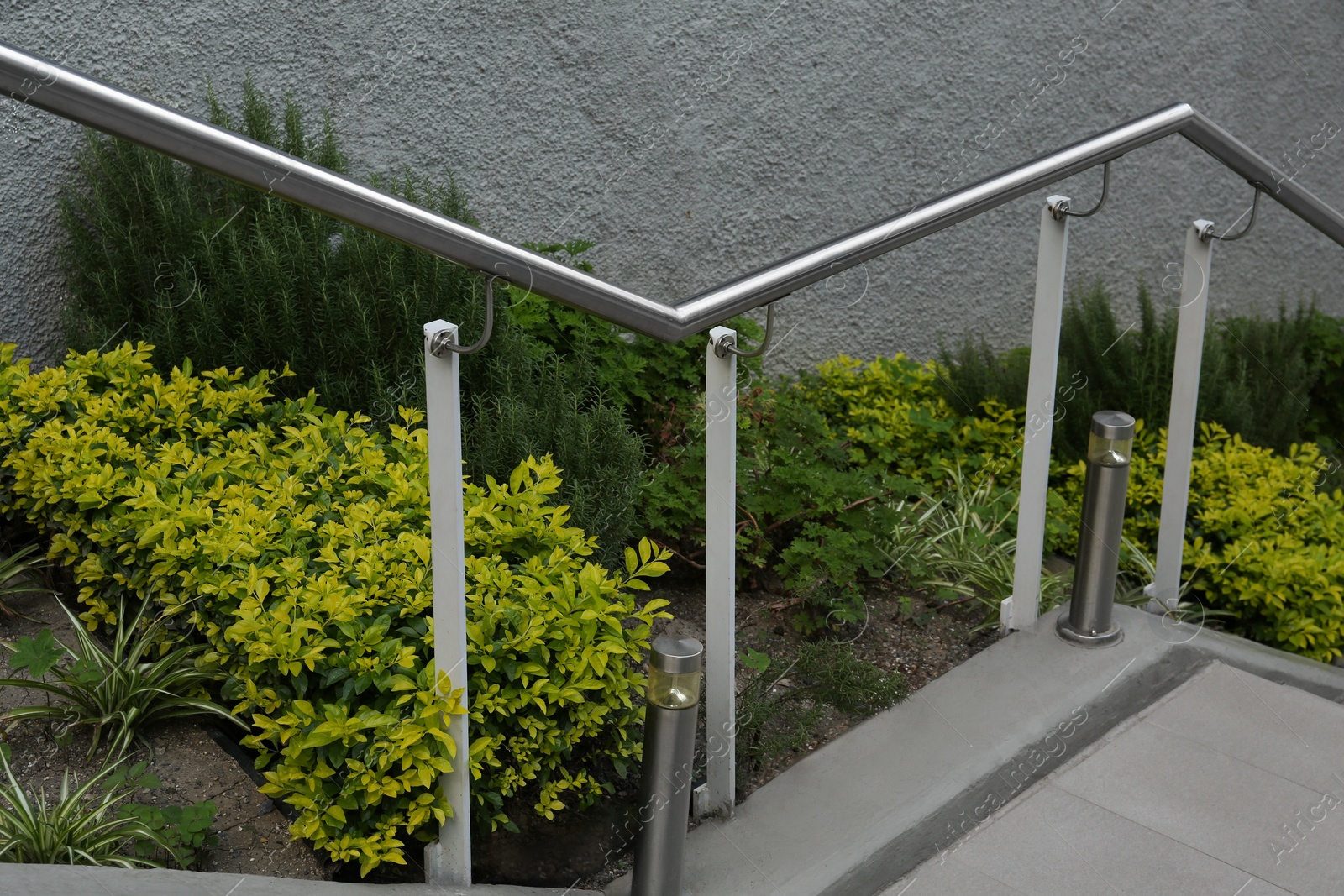 Photo of Outdoor staircase with metal handrails near beautiful plants