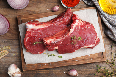 Flat lay composition with fresh beef cut on wooden table