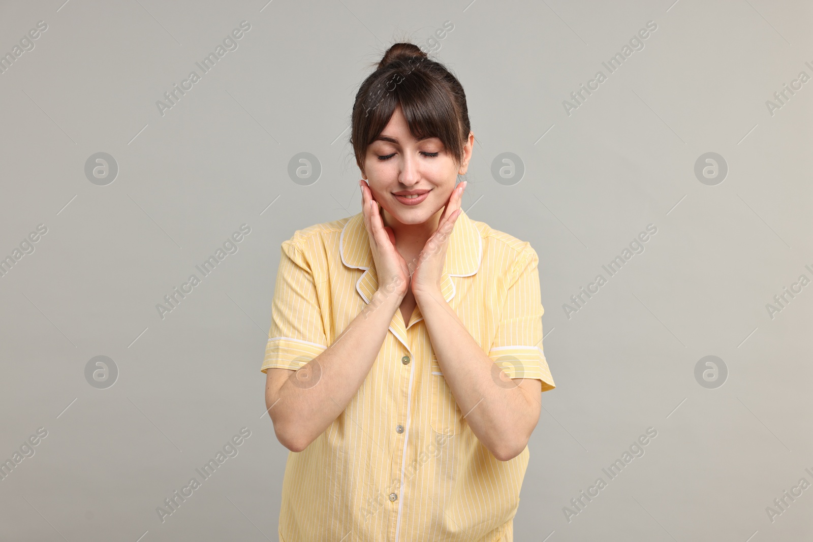 Photo of Happy woman in pyjama on grey background