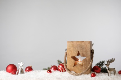 Photo of Composition with wooden Christmas lantern on snow against light grey background, space for text