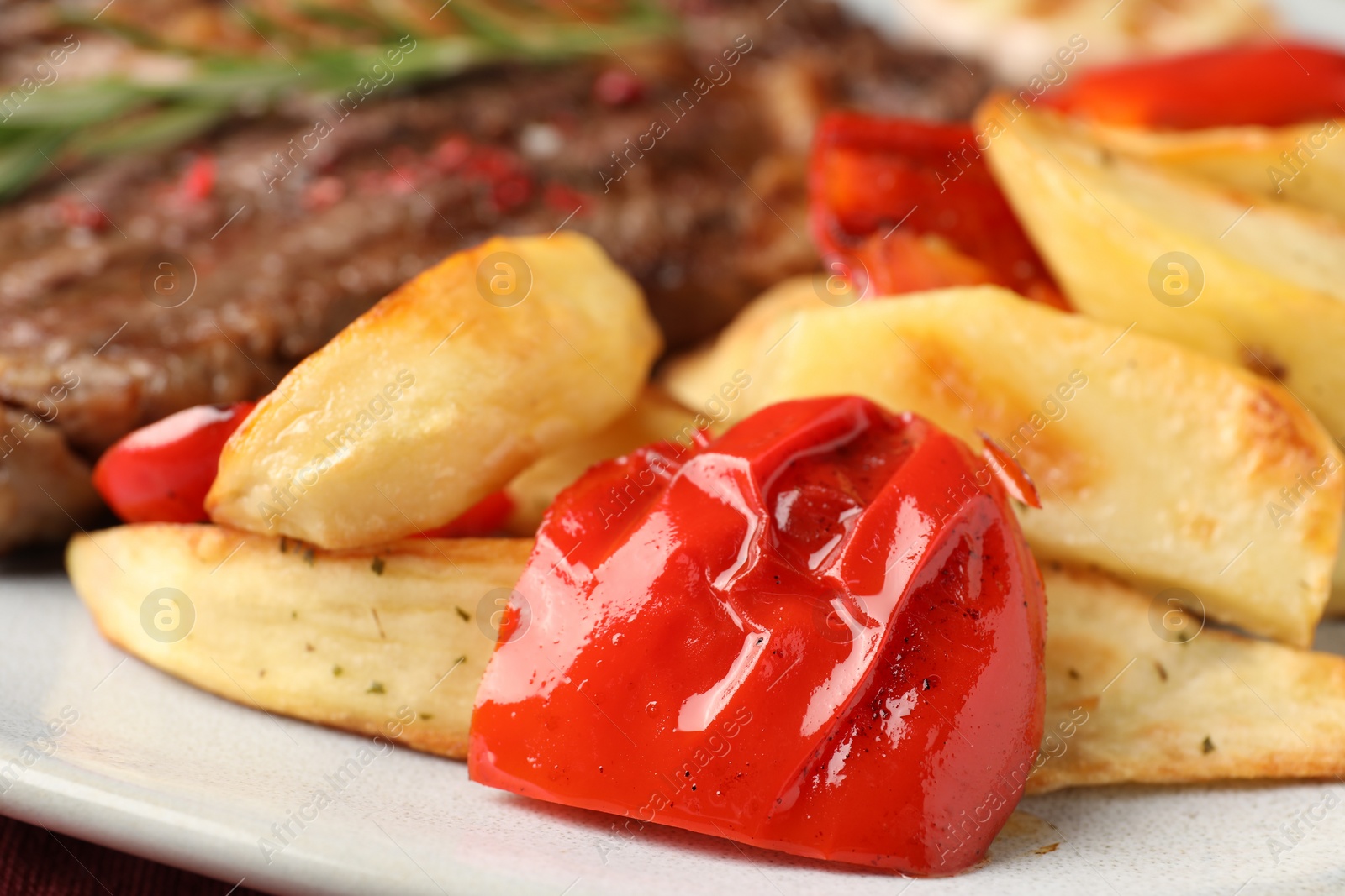 Photo of Delicious grilled bell pepper and potatoes on plate, closeup