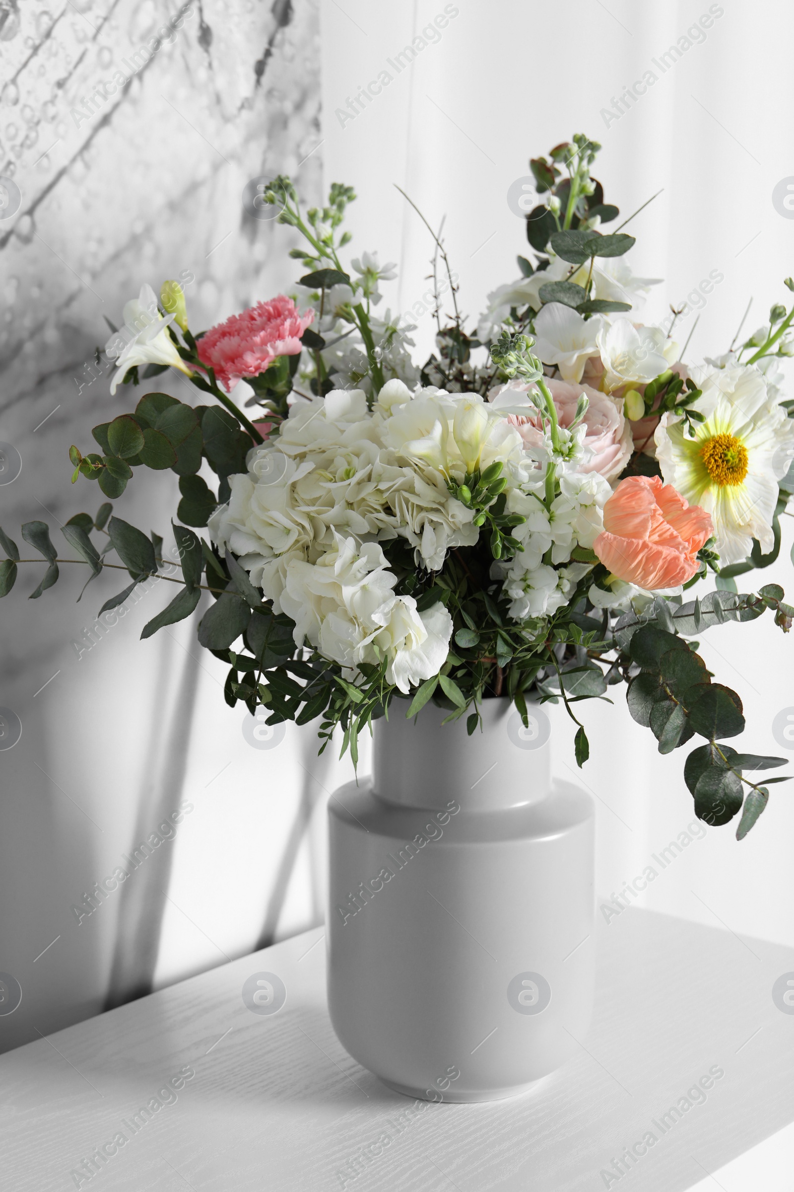 Photo of Bouquet of beautiful flowers on white table indoors