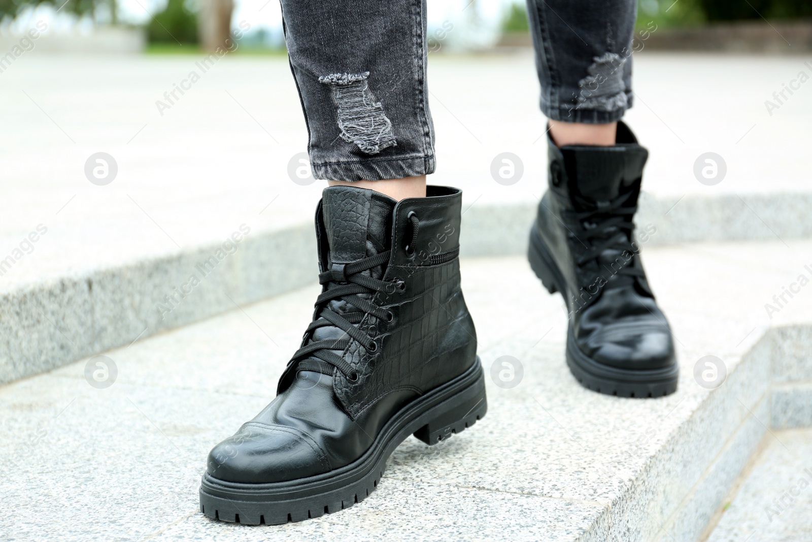 Photo of Woman wearing comfortable stylish boots outdoors, closeup