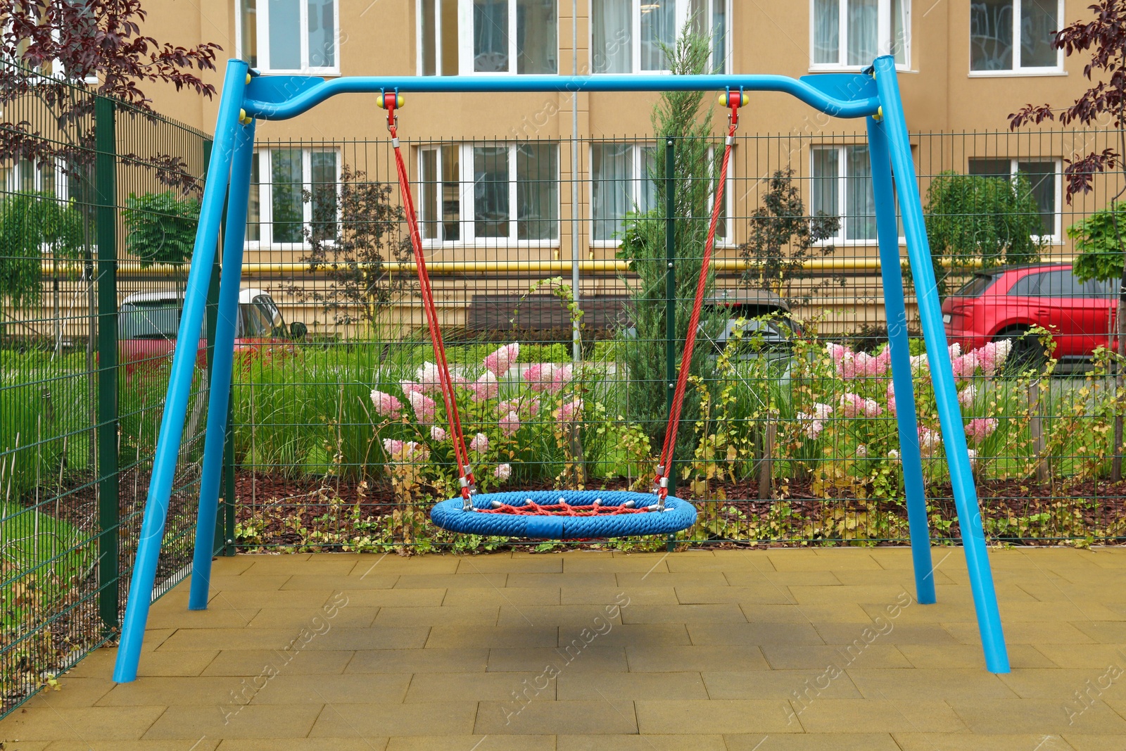 Photo of Light blue nest swing on outdoor playground in residential area