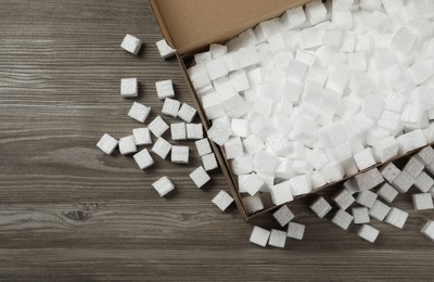 Photo of Cardboard box and styrofoam cubes on wooden floor, flat lay