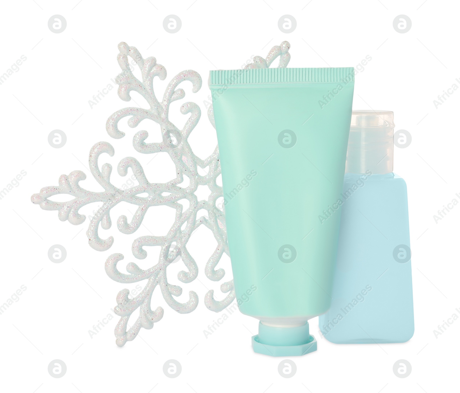 Photo of Set of cosmetic products with hand cream and snowflake isolated on white. Winter skin care