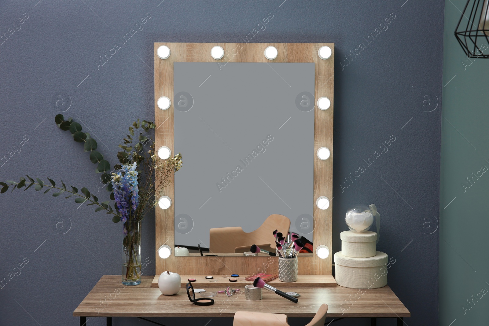 Photo of Table with beautiful mirror and cosmetics in modern makeup room