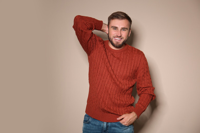 Image of Handsome man wearing warm sweater on beige background 