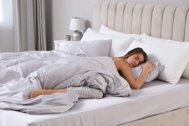 Photo of Beautiful woman sleeping in comfortable bed with silky linens