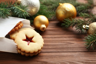 Photo of Traditional Christmas Linzer cookies with sweet jam on wooden table