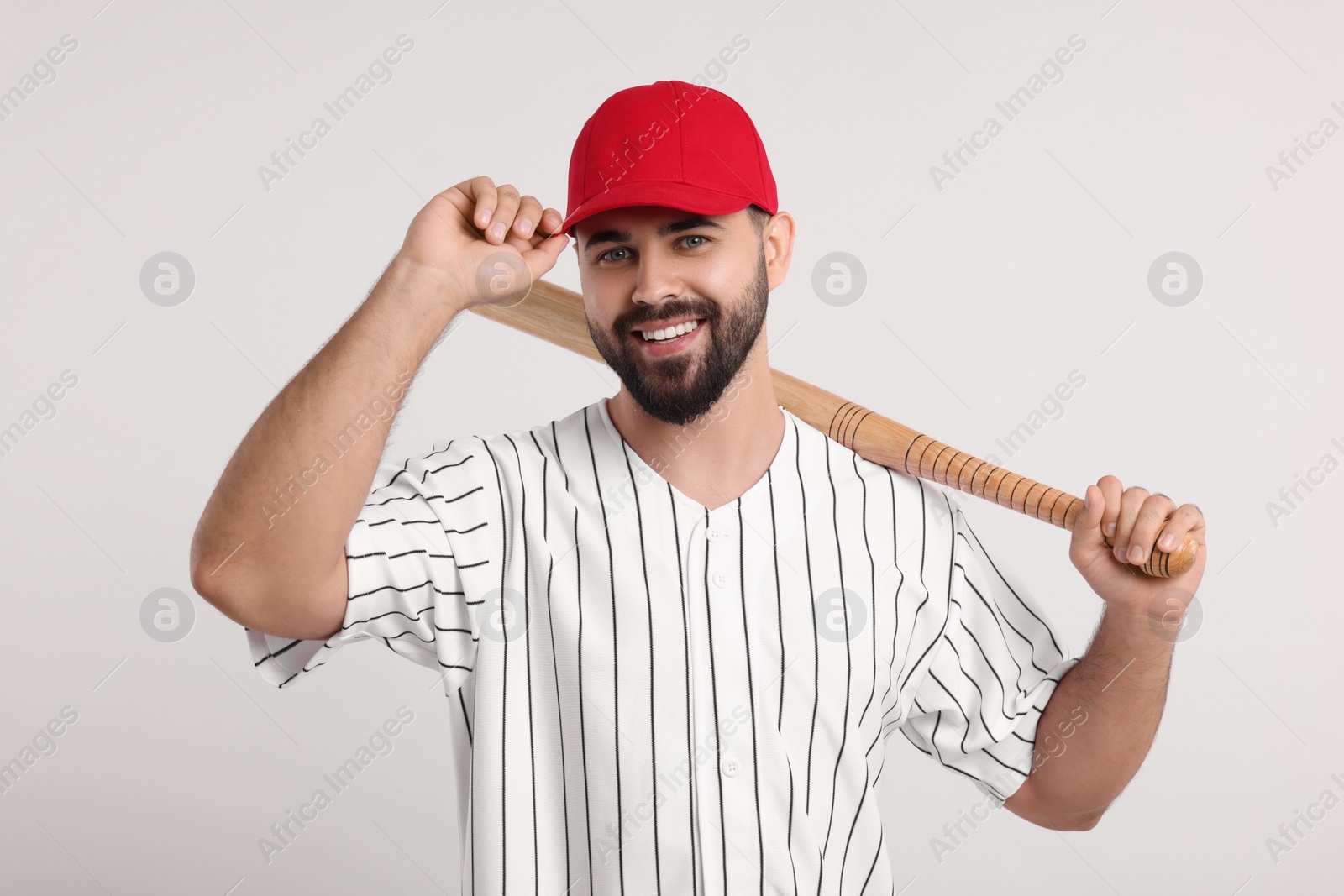 Photo of Man in stylish red baseball cap holding bat on white background