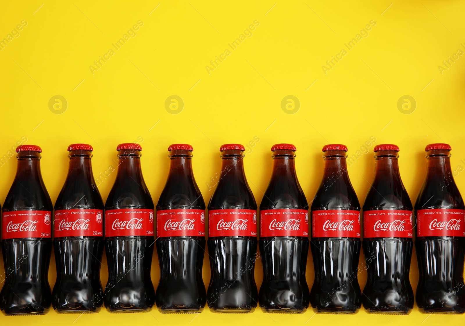 Photo of MYKOLAIV, UKRAINE - NOVEMBER 14, 2018: Bottles of Coca-Cola on color background, flat lay. Space for text