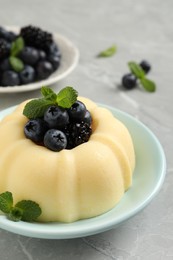 Delicious semolina pudding with berries on light grey table