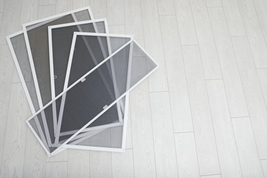 Photo of Set of window screens on wooden floor, flat lay. Space for text