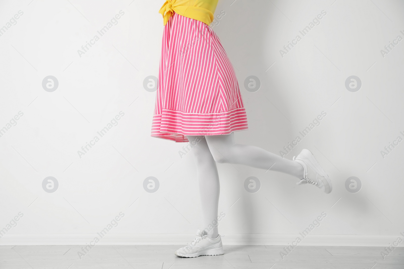 Photo of Woman wearing tights near white wall, closeup