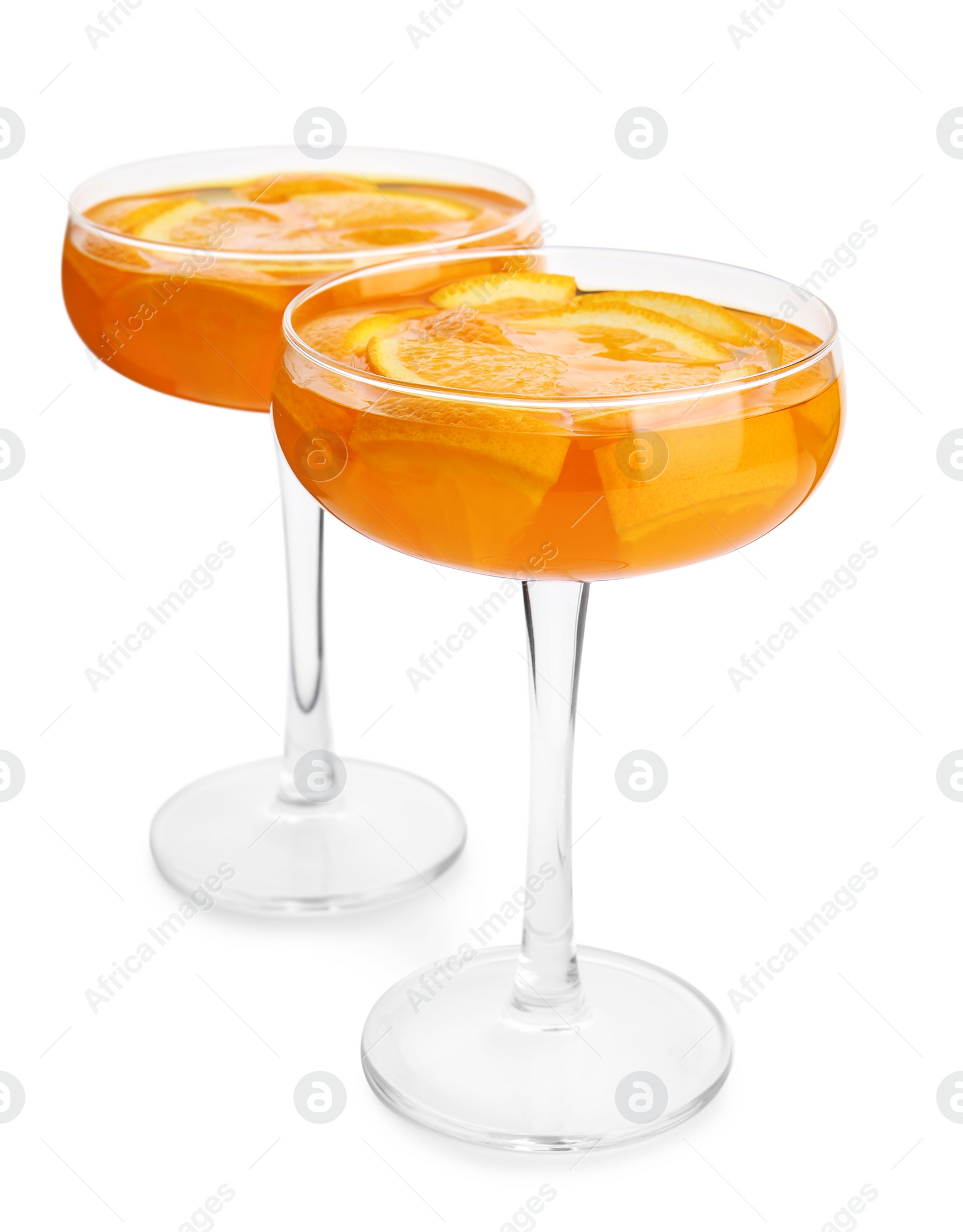 Photo of Tasty jelly desserts with slices of orange in glasses on white background