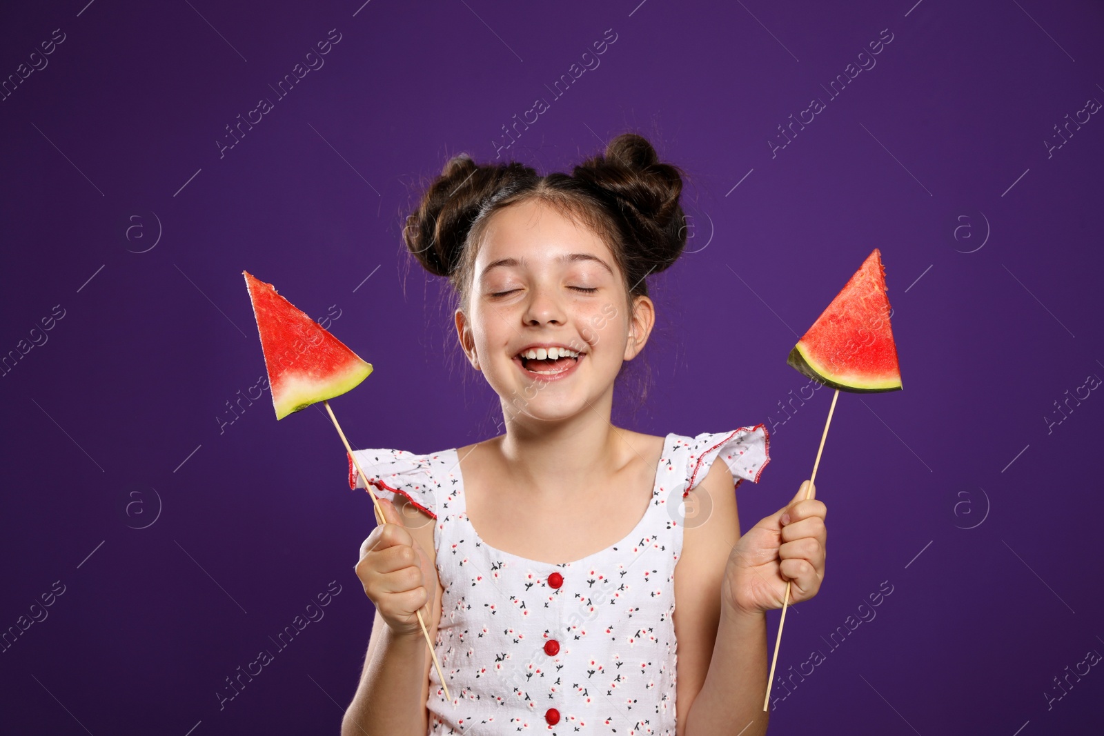 Photo of Cute little girl with watermelon on purple background