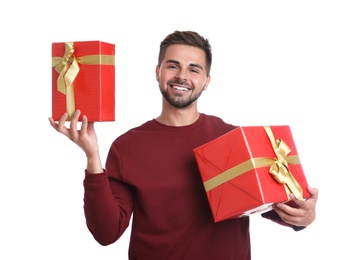 Happy young man holding Christmas gifts on white background