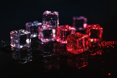 Photo of Pile of crystal clear ice cubes on black background