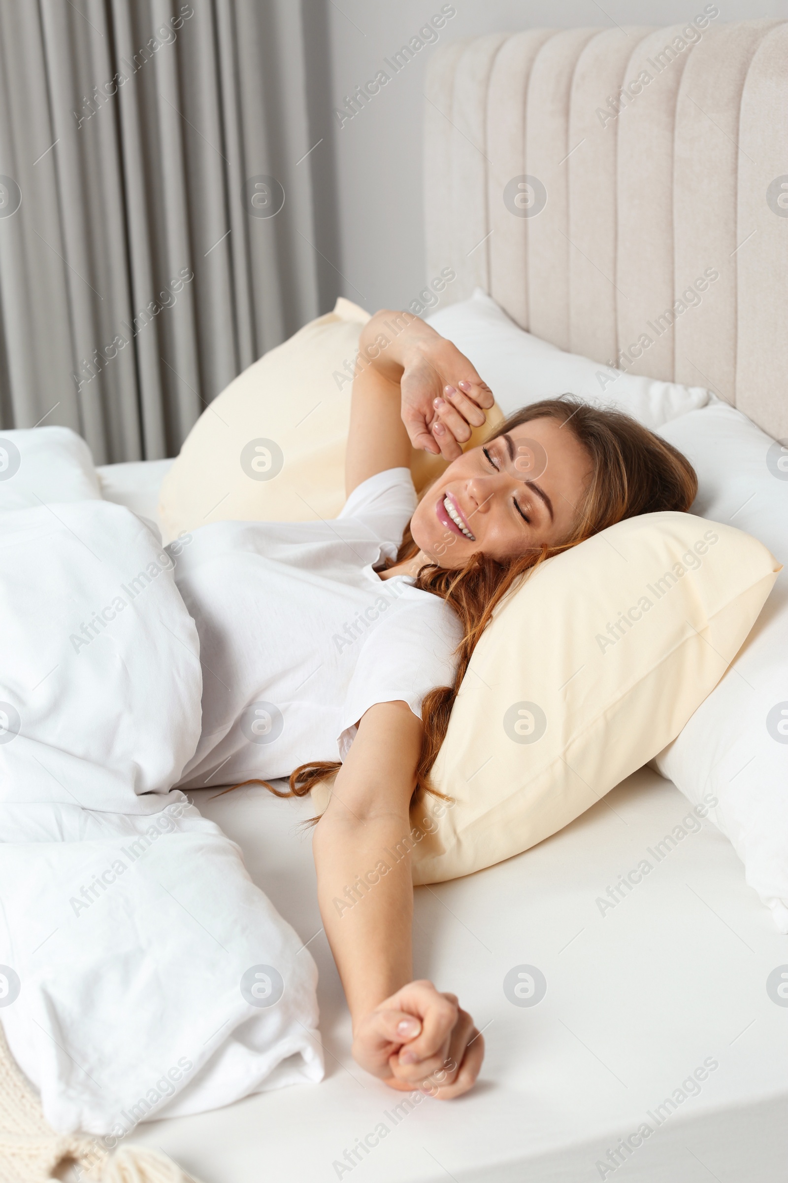 Photo of Beautiful woman stretching in bed at home