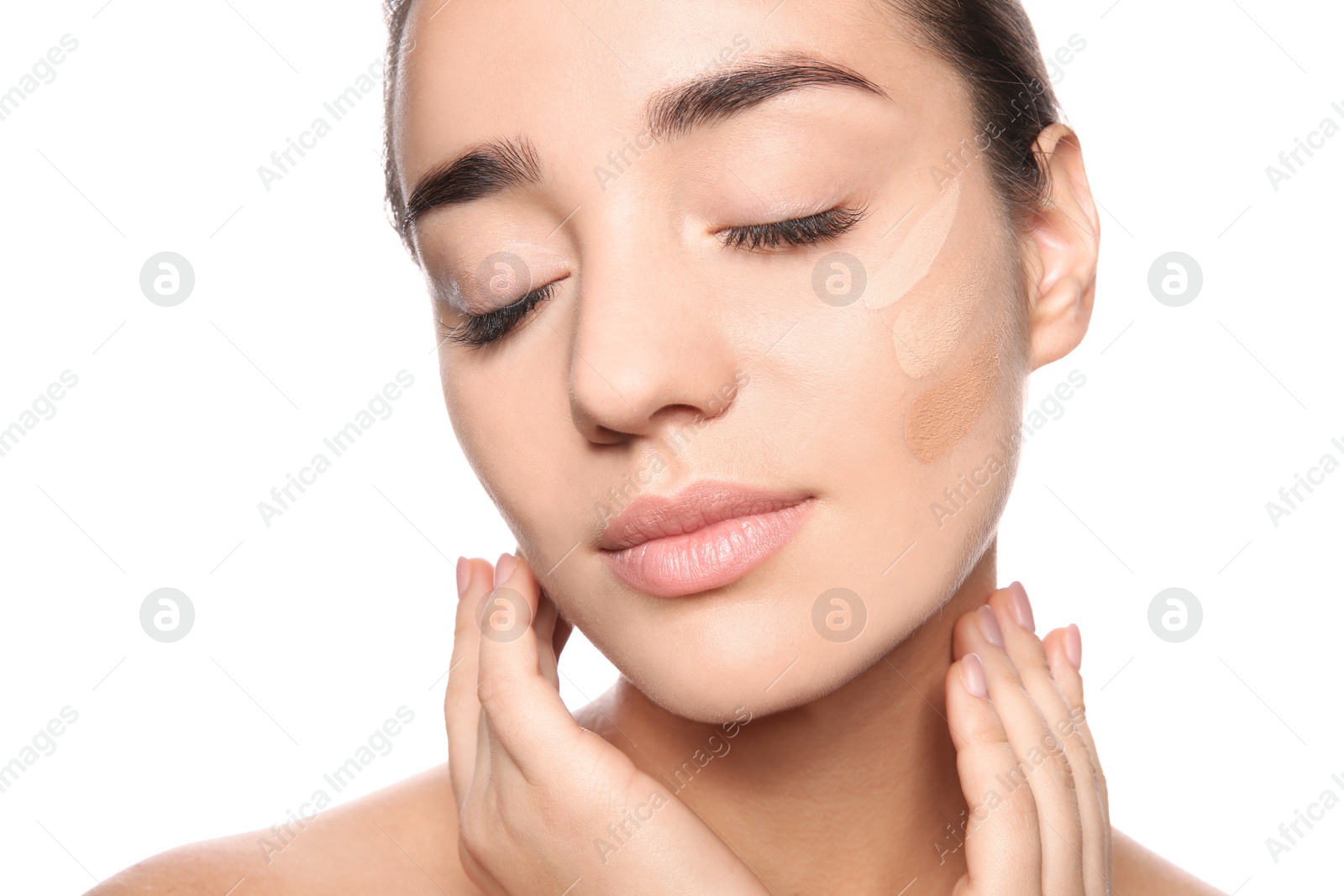 Photo of Young woman with different shades of skin foundation on her face against white background