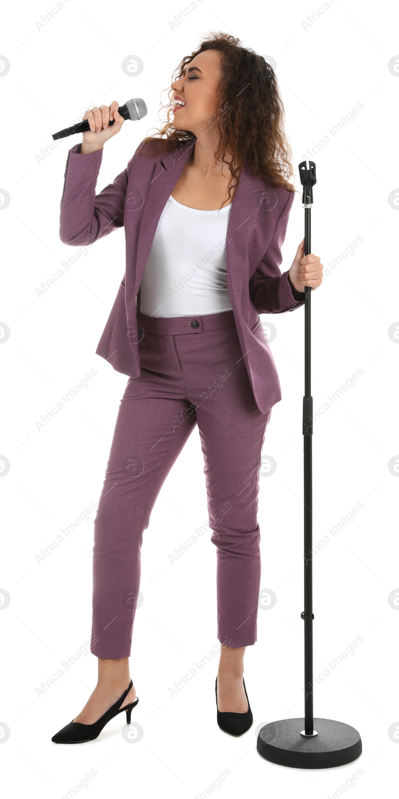 Photo of Curly African-American woman in suit singing with microphone on white background