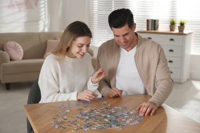 Happy couple playing with puzzles at home