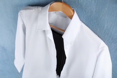 Shirt hanging on blue background. School uniform