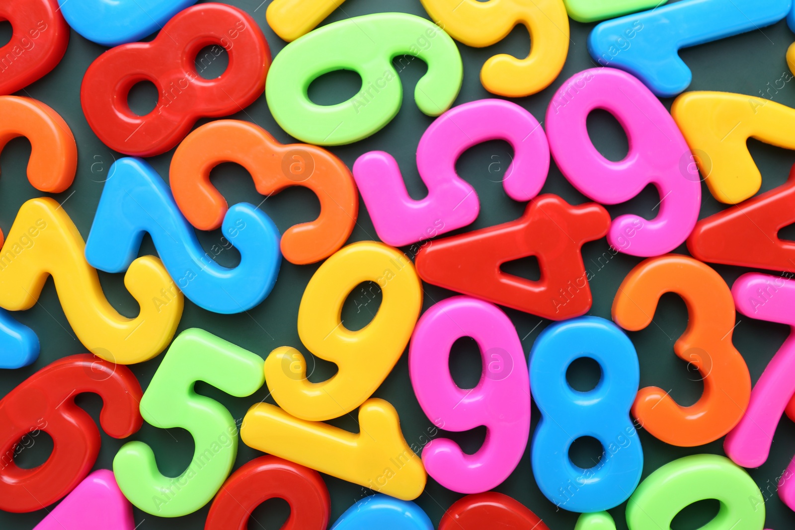 Photo of Colorful numbers on green background, top view