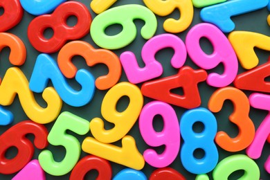 Photo of Colorful numbers on green background, top view