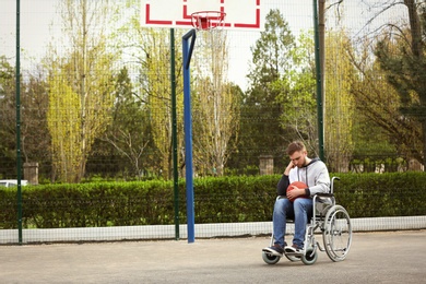 Photo of Upset man in wheelchair with ball on sports ground
