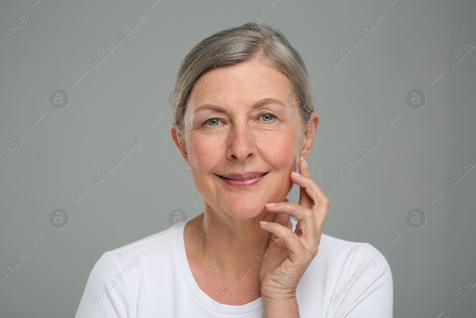 Photo of Portrait of senior woman with aging skin on grey background. Rejuvenation treatment