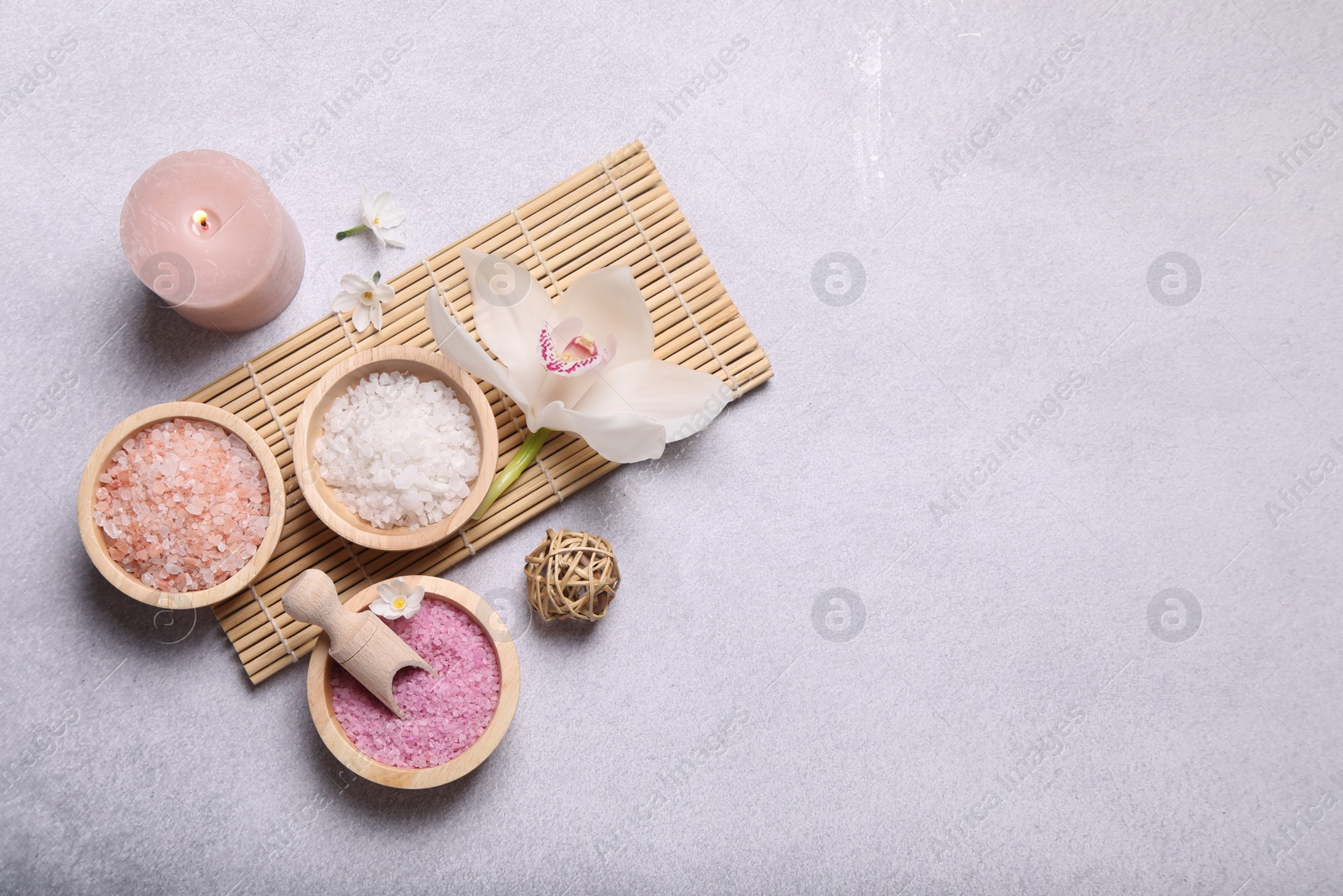 Photo of Flat lay composition with different spa products and orchid on light grey table. Space for text