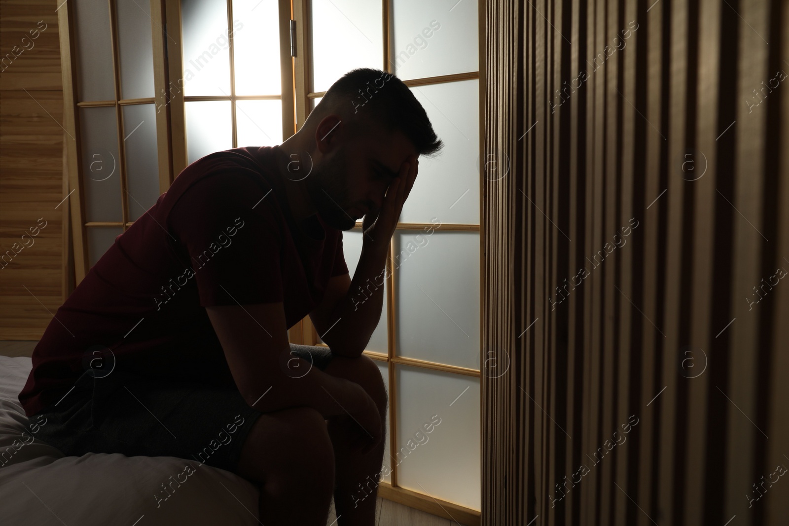 Photo of Silhouette of sad man at home. Space for text