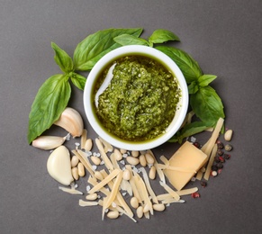 Photo of Flat lay composition with pesto sauce and ingredients on grey table