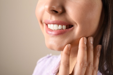 Photo of Young woman with healthy teeth on color background, closeup