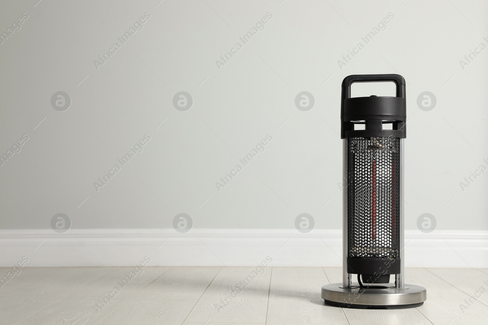 Photo of New modern electric heater on floor in room, space for text