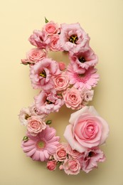 Number 8 made of beautiful pink flowers on beige background, flat lay. International Women's day